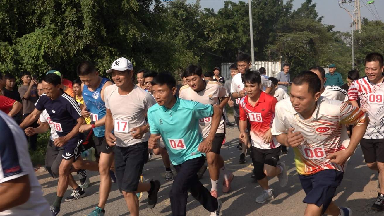 A group of people running on a road  Description automatically generated