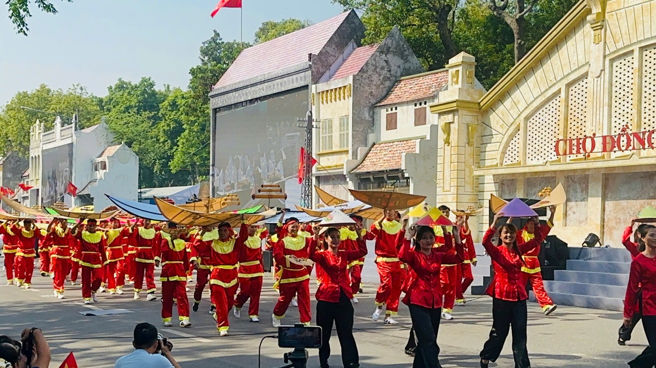 A group of people in red and yellow uniforms walking on a street  Description automatically generated