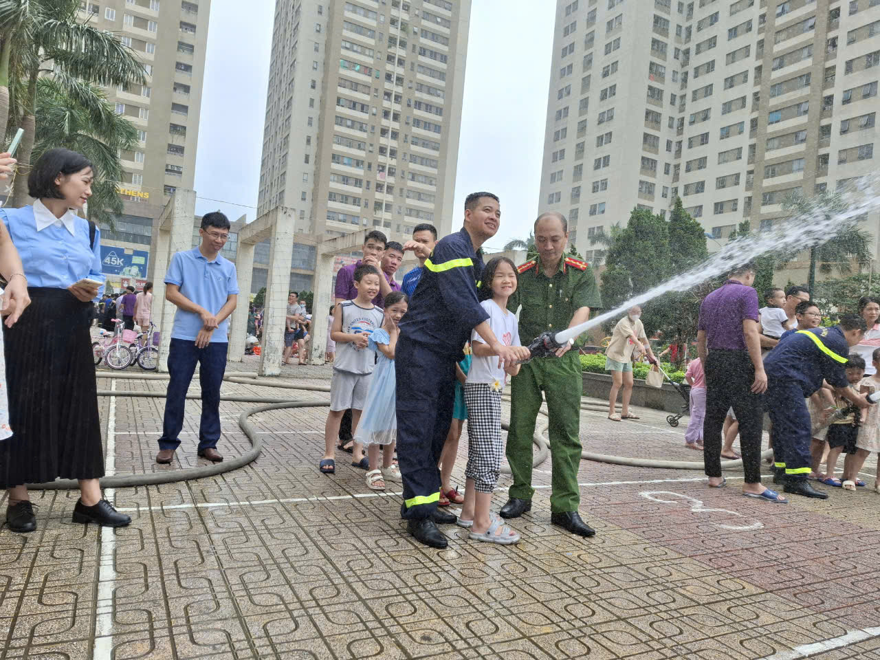 A person spraying water from a hose  Description automatically generated