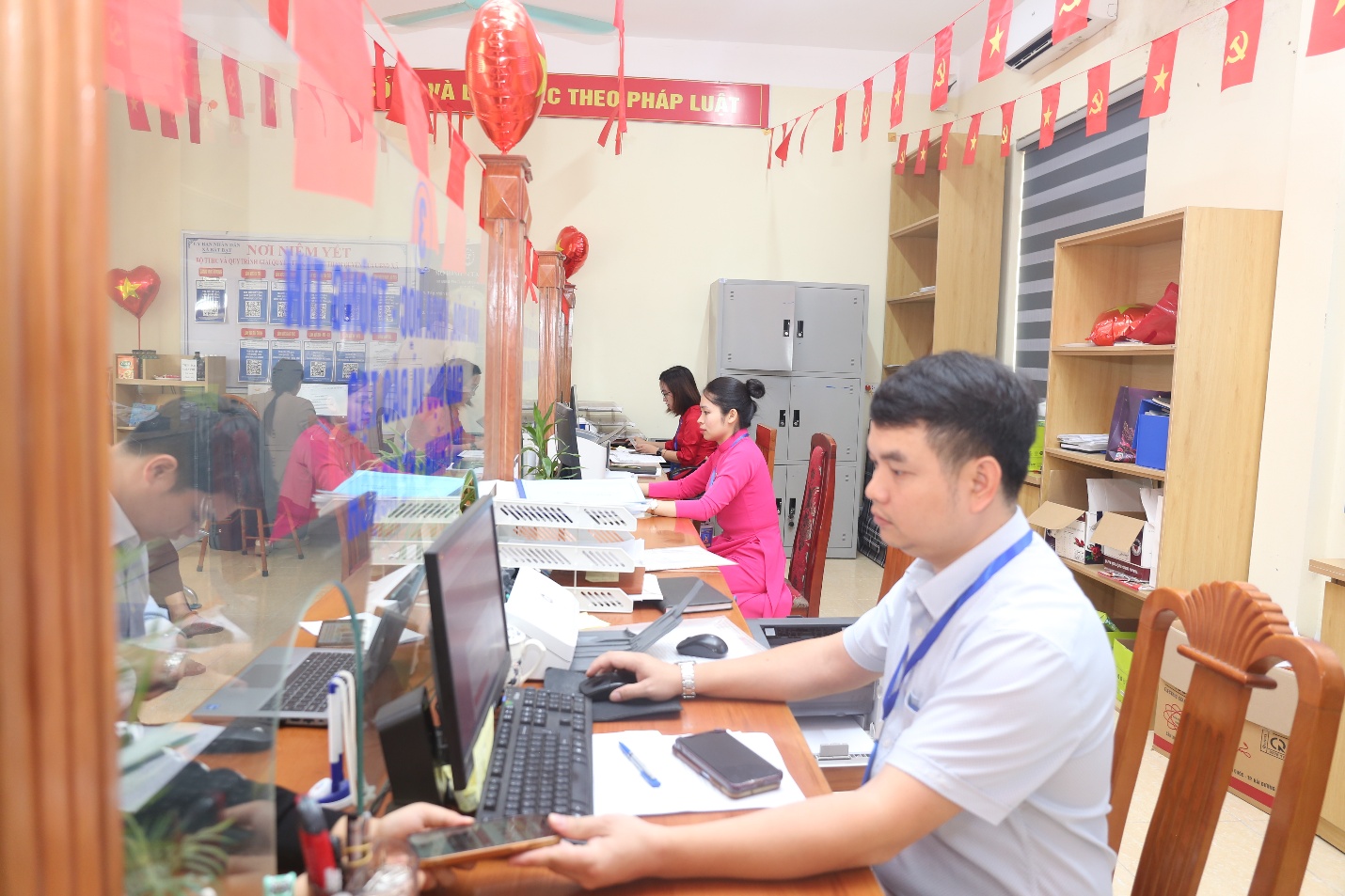 A group of people working at a desk  Description automatically generated