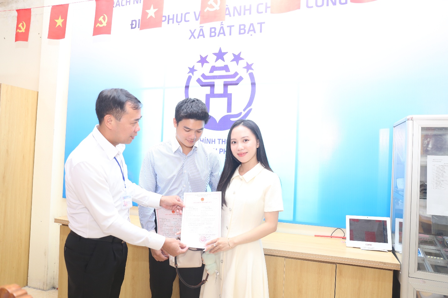 A group of people holding a piece of paper  Description automatically generated