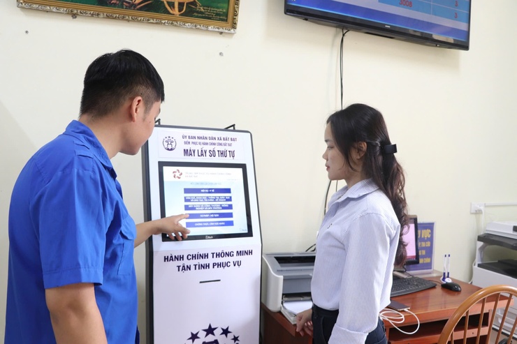 A person and person standing next to a screen  Description automatically generated