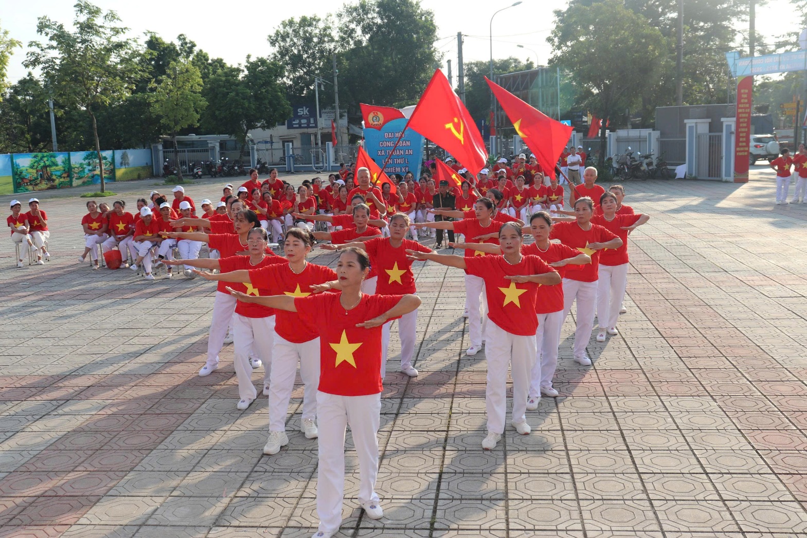A group of people in red shirts holding flags  AI-generated content may be incorrect.