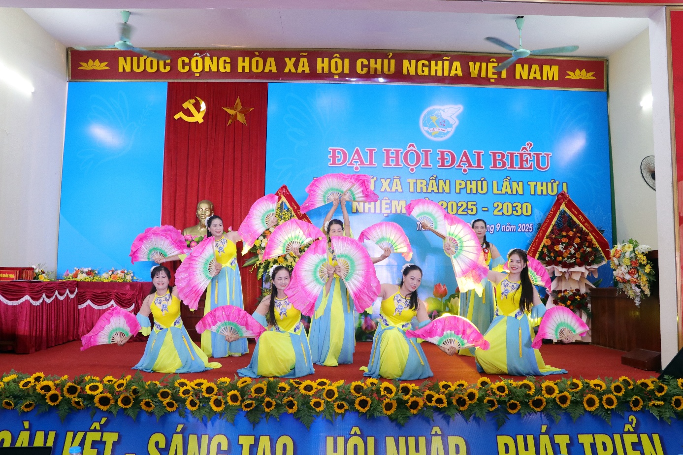 A group of women in colorful dresses on a stage  AI-generated content may be incorrect.