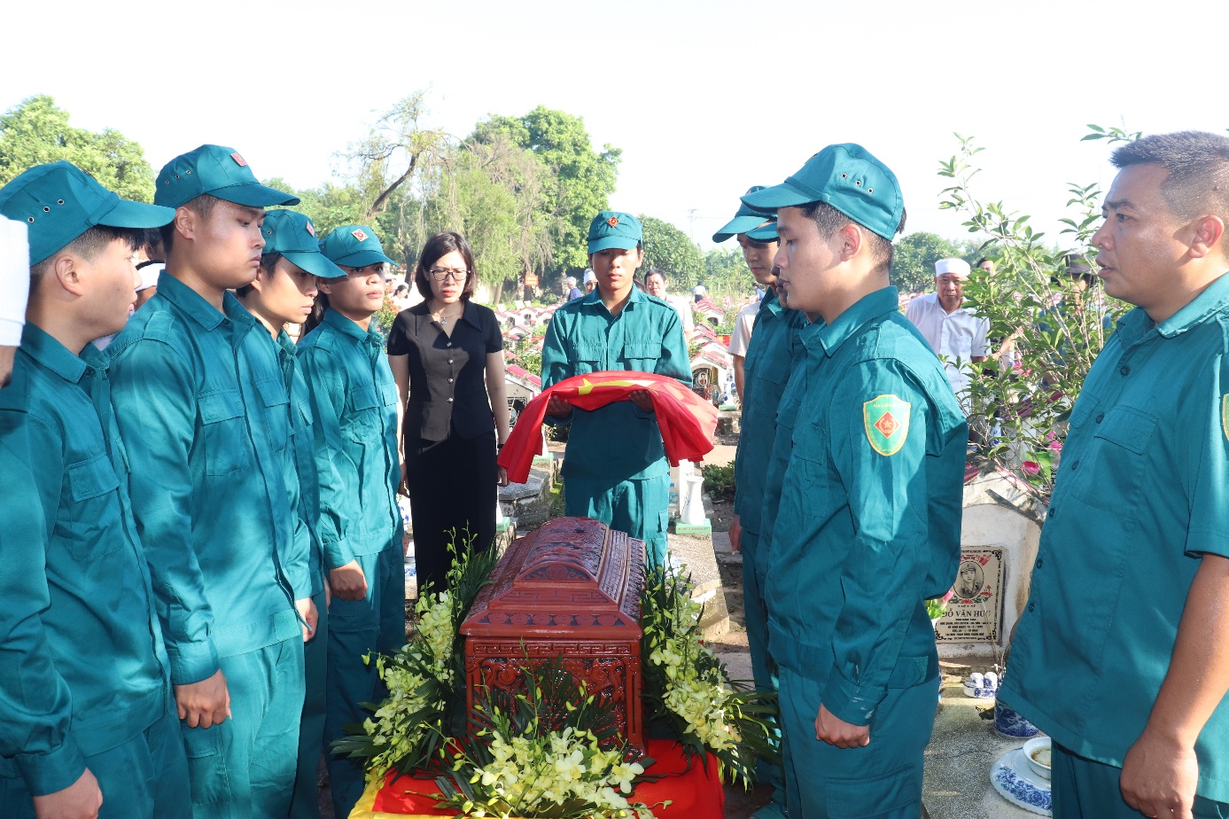 A group of people standing around a casket  AI-generated content may be incorrect.