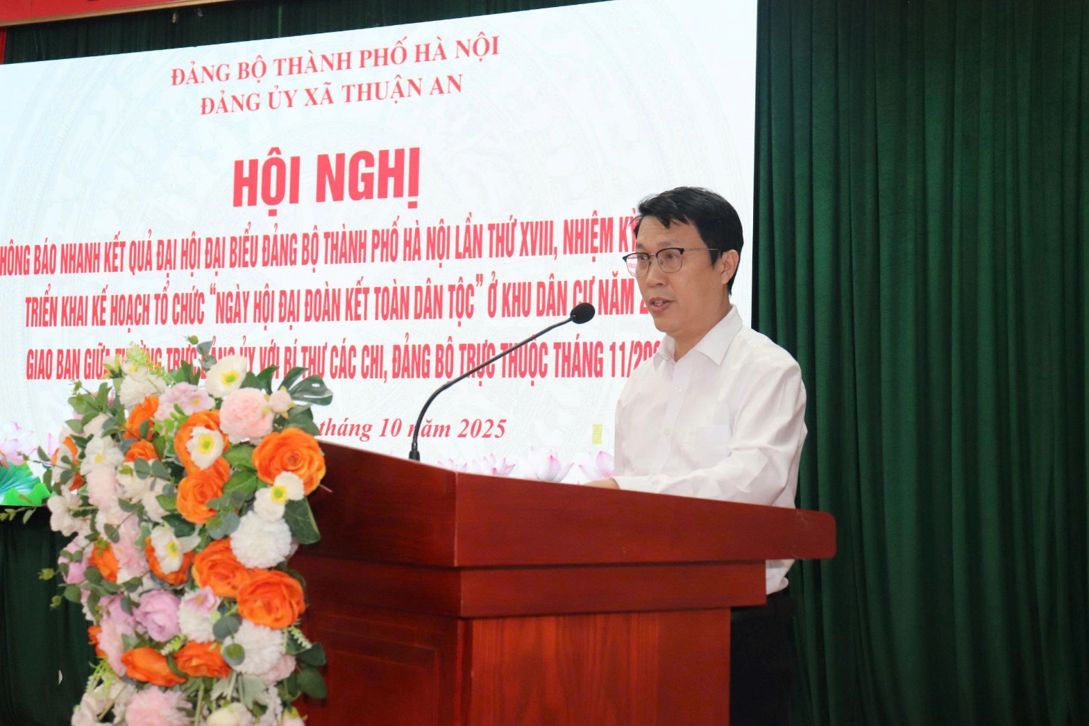 Ảnh có chứa hoa, Diễn thuyết công cộng, Bục phát biểu, Người phát biểu  Nội dung do AI tạo ra có thể không chính xác.