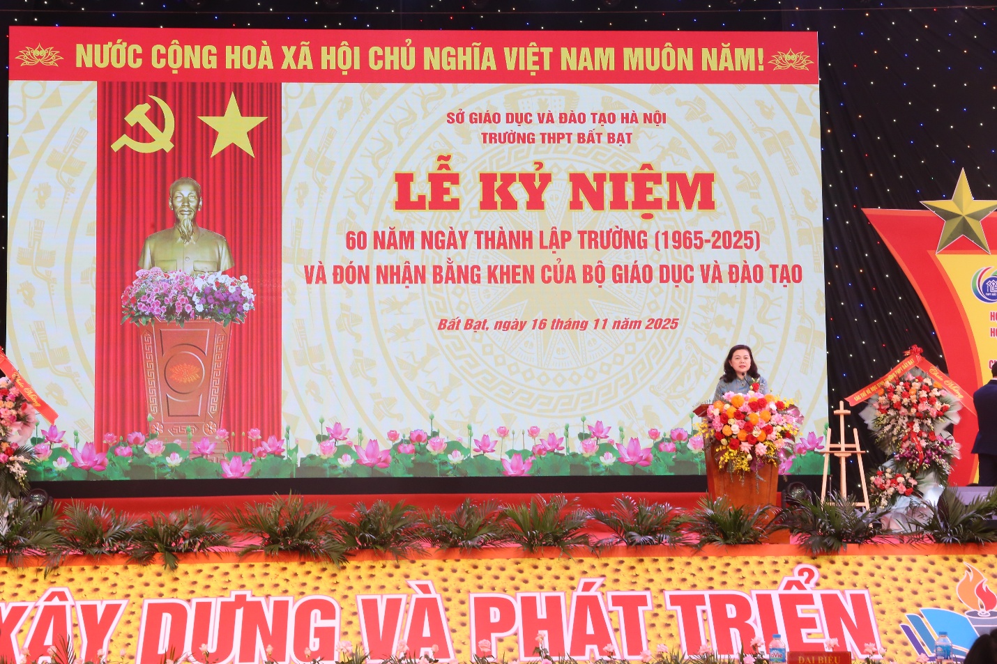 A person standing in front of a large screen  Description automatically generated