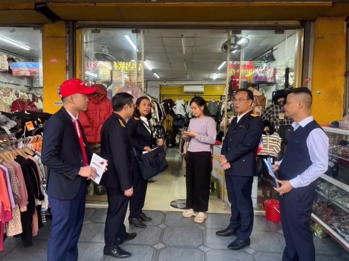 A group of people standing in front of a store  Description automatically generated