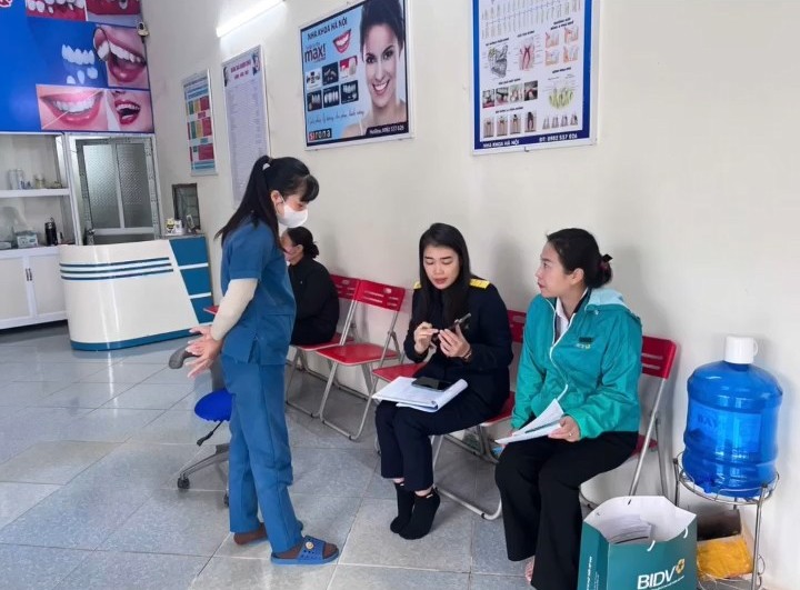 A person in a blue uniform talking to a group of people  Description automatically generated