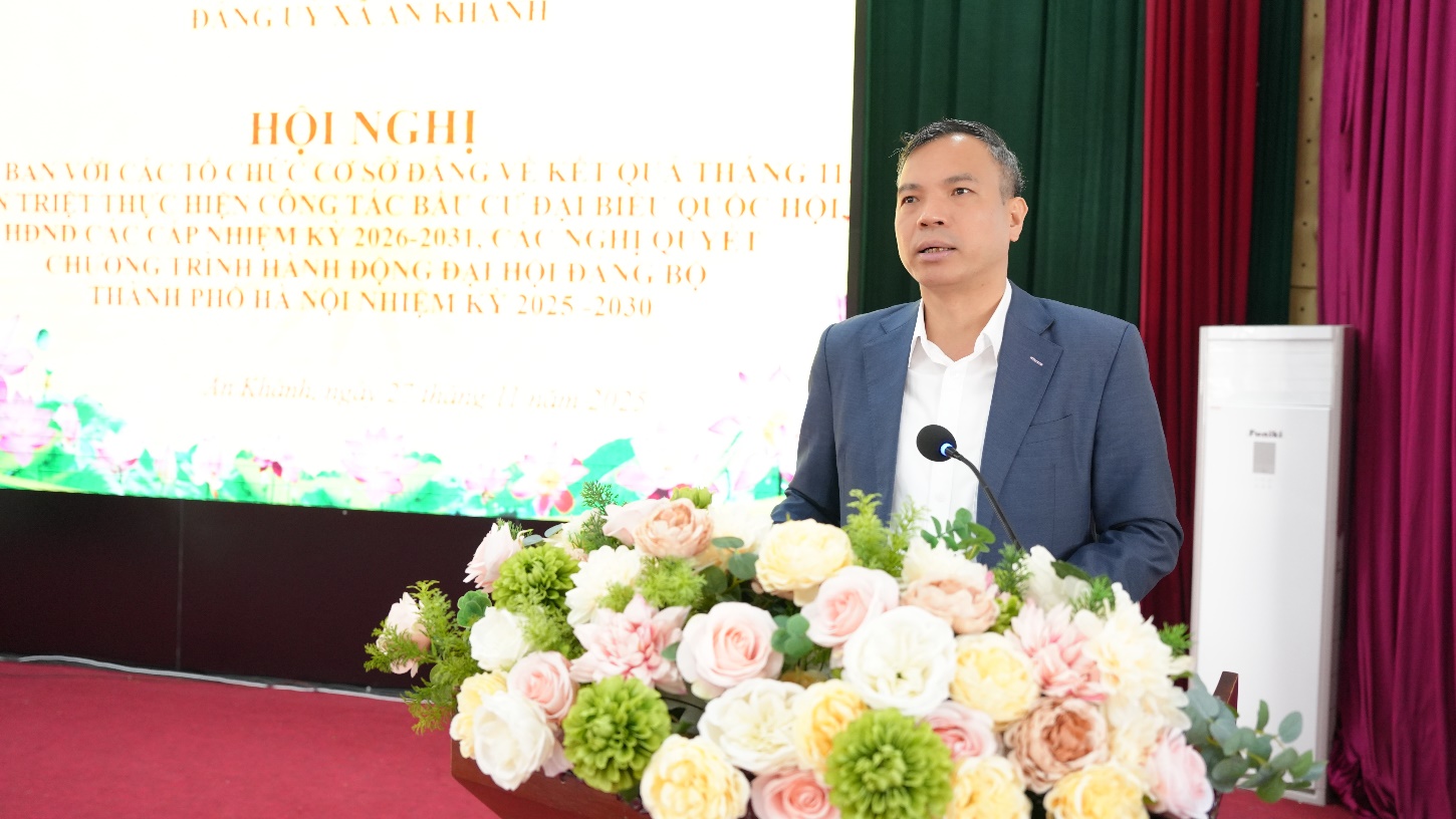 A person standing at a podium with a microphone and flowers  AI-generated content may be incorrect.