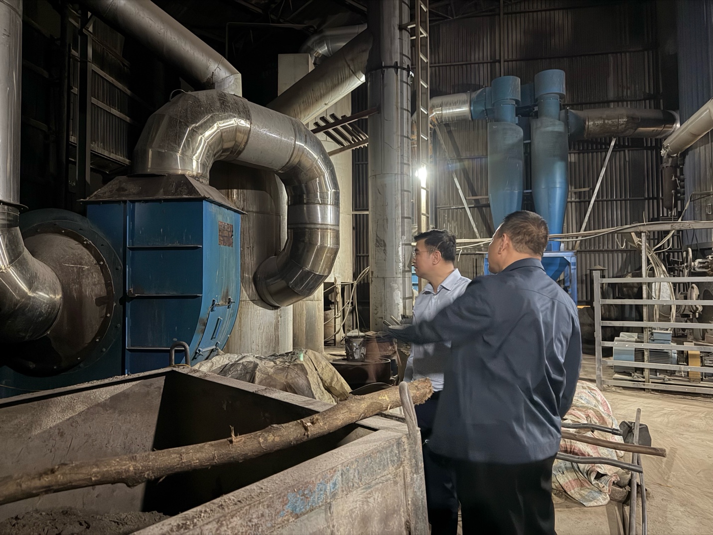 Men standing in a factory  AI-generated content may be incorrect.