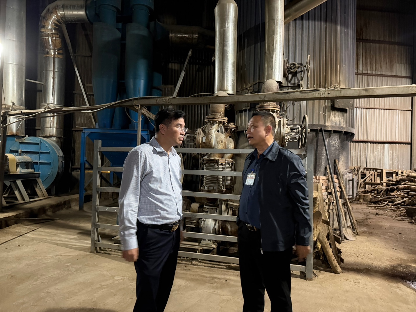 Men standing in a factory  AI-generated content may be incorrect.