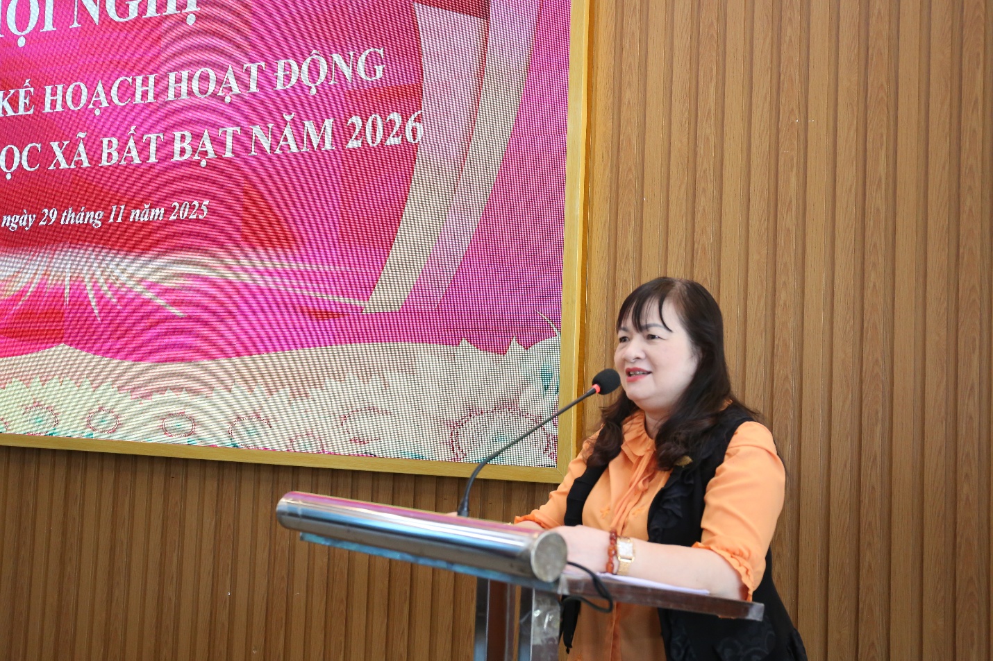 A person standing at a podium with a microphone  Description automatically generated