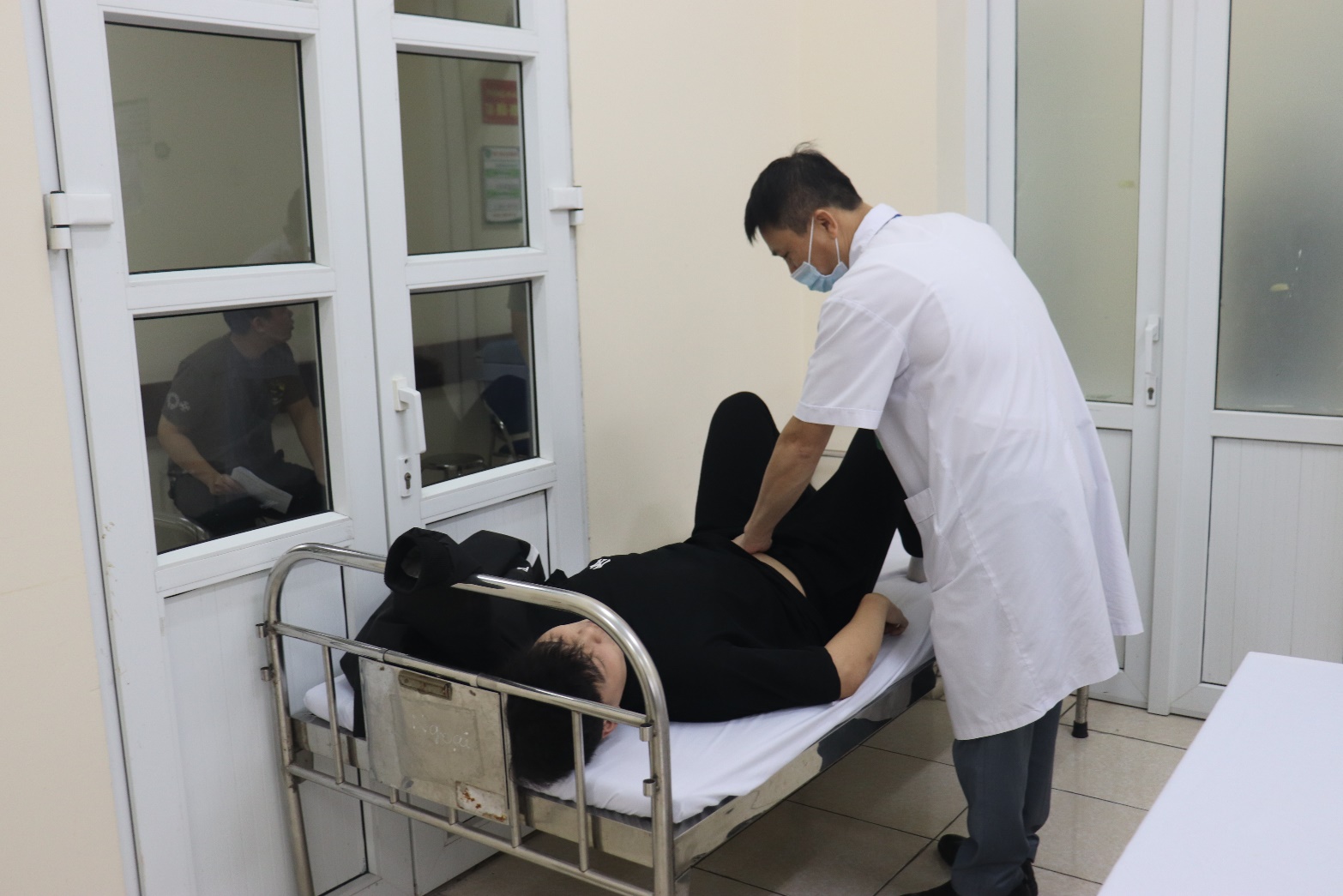 A person in a white coat and a mask on a bed  AI-generated content may be incorrect.