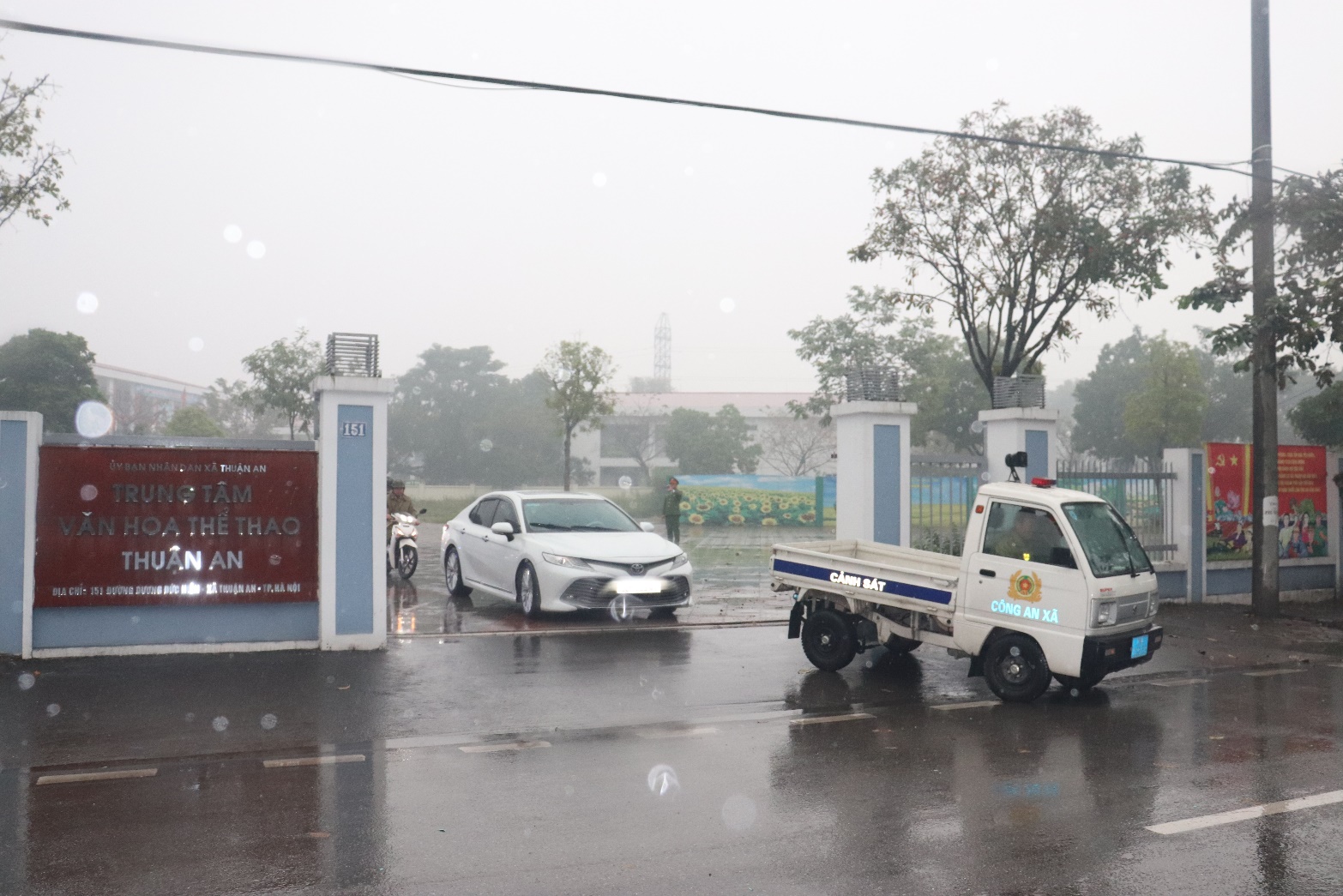 A white truck and a car parked on a wet road  AI-generated content may be incorrect.