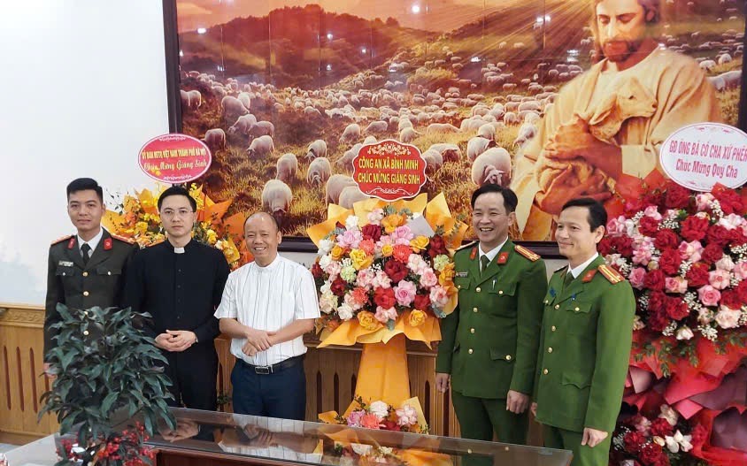 Ảnh: Lãnh đạo Công an xã Bình Minh tặng hoa, chúc mừng Lễ Giáng sinh năm 2025 tại Giáo xứ Thạch Bích.