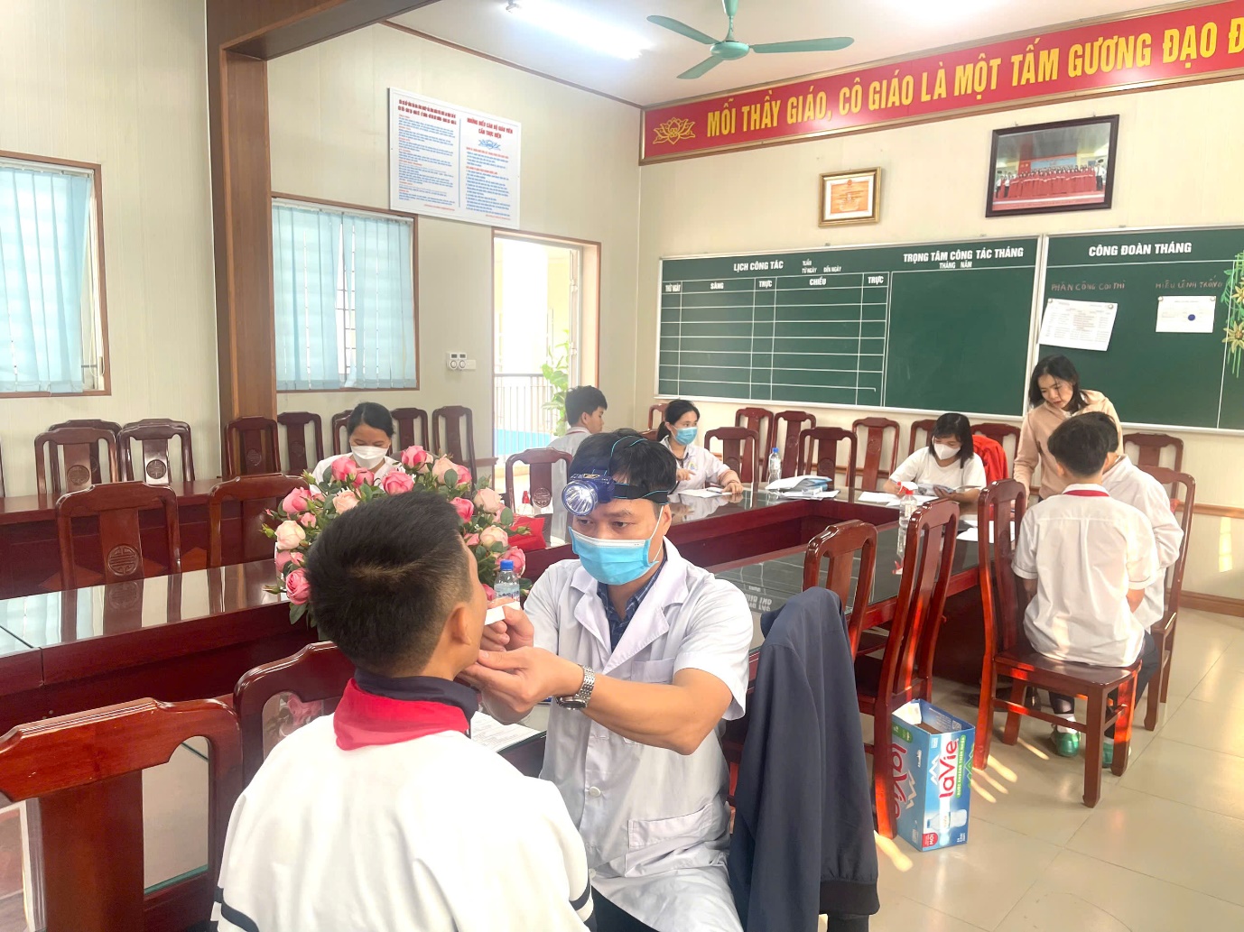 A person in a mask sitting in a classroom  AI-generated content may be incorrect.