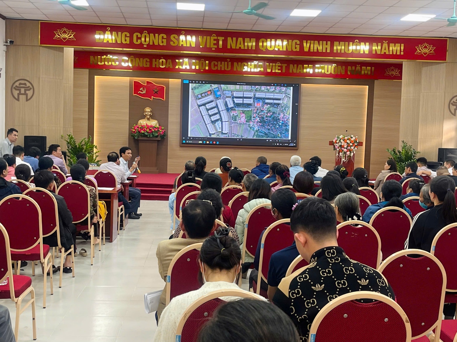 Ảnh có chứa trang phục, ghế, trong nhà, thính phòng  Nội dung do AI tạo ra có thể không chính xác.