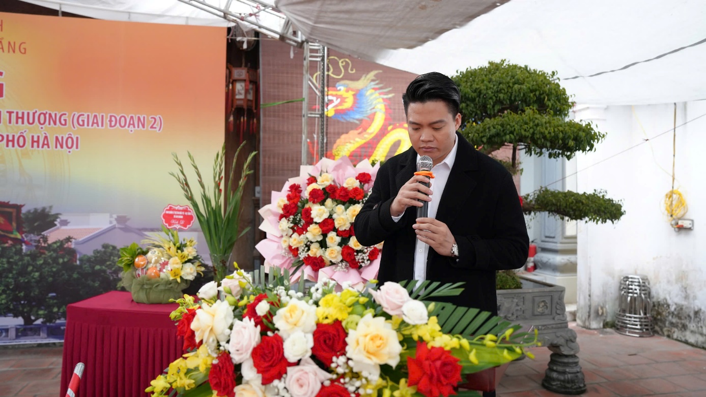 A person holding a microphone in front of a bouquet of flowers  AI-generated content may be incorrect.