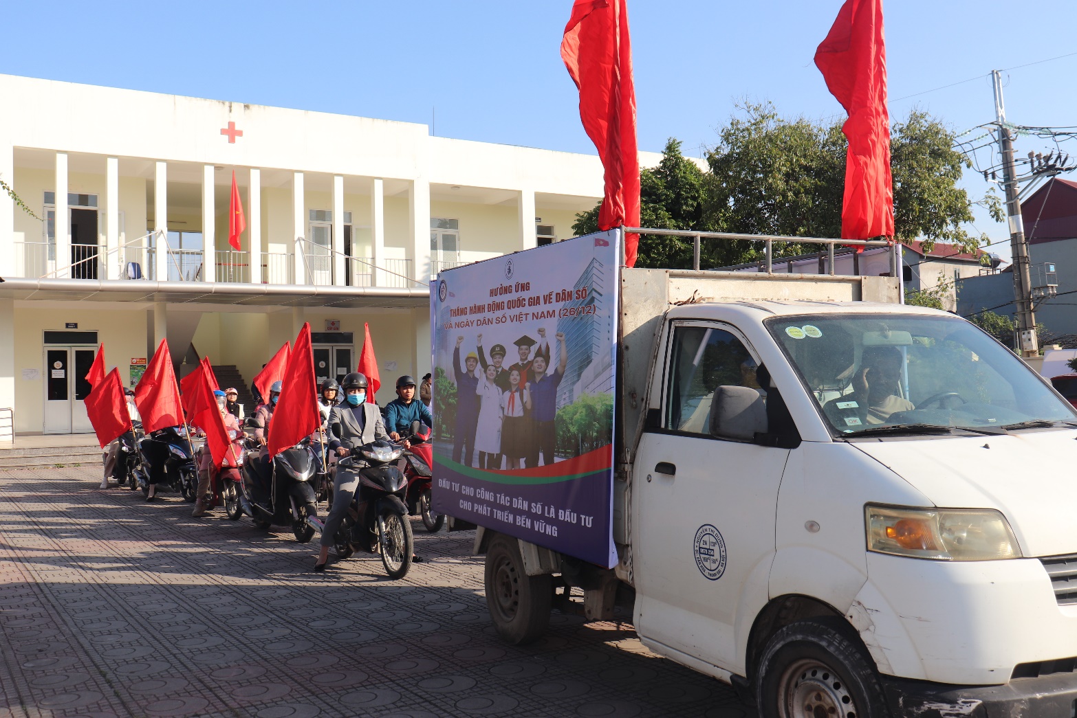 A white truck with a sign and red flags  AI-generated content may be incorrect.