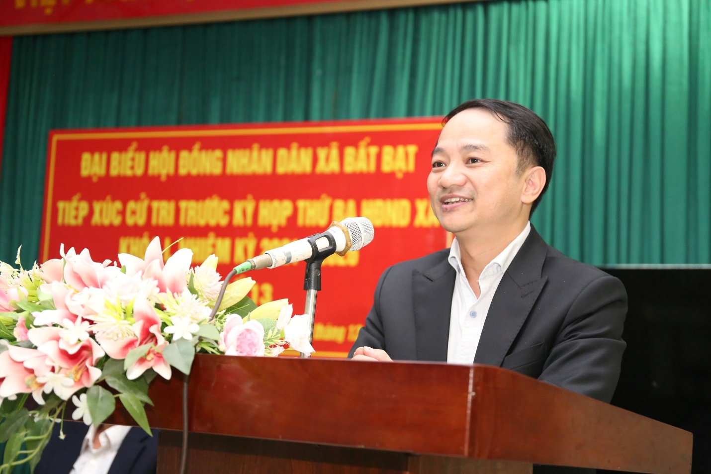 A person standing at a podium with a microphone  Description automatically generated