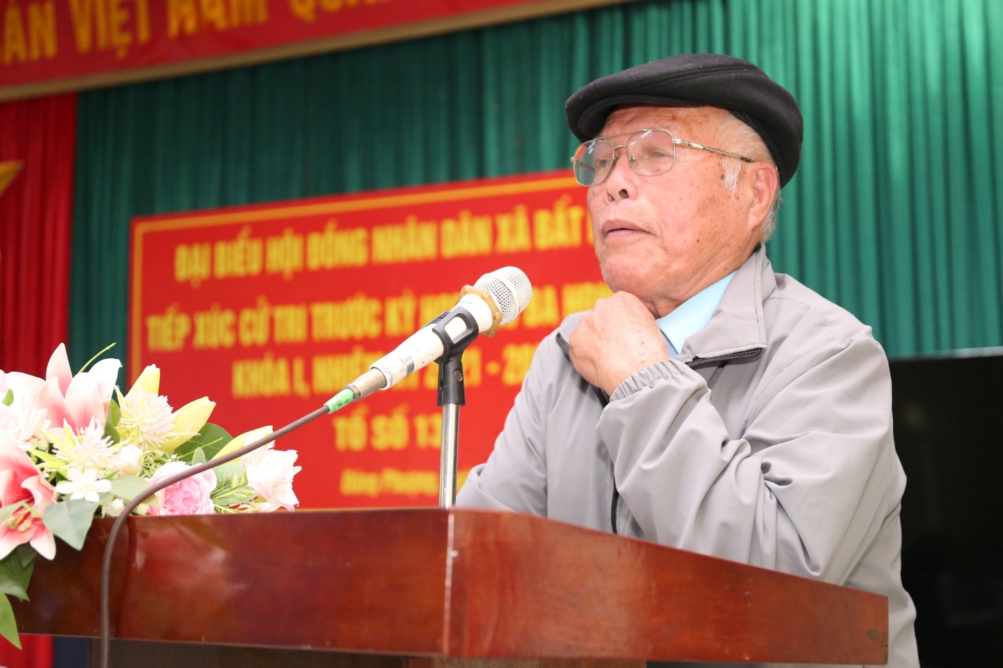 A person speaking into a microphone  Description automatically generated