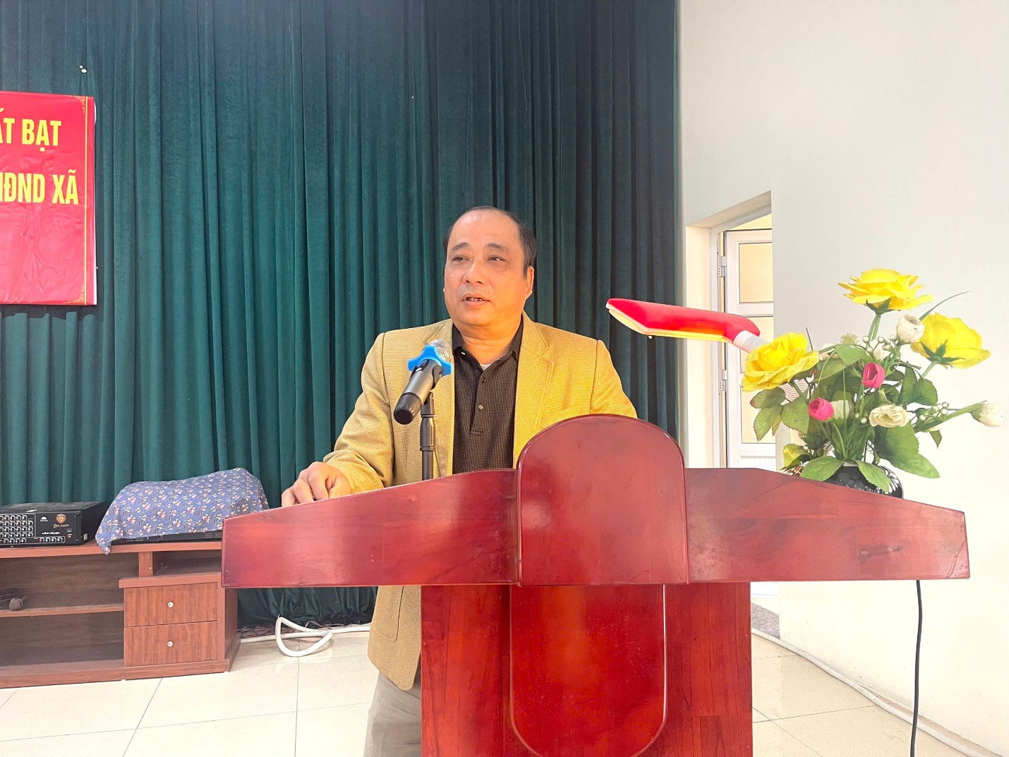 A person standing behind a podium with a microphone  Description automatically generated