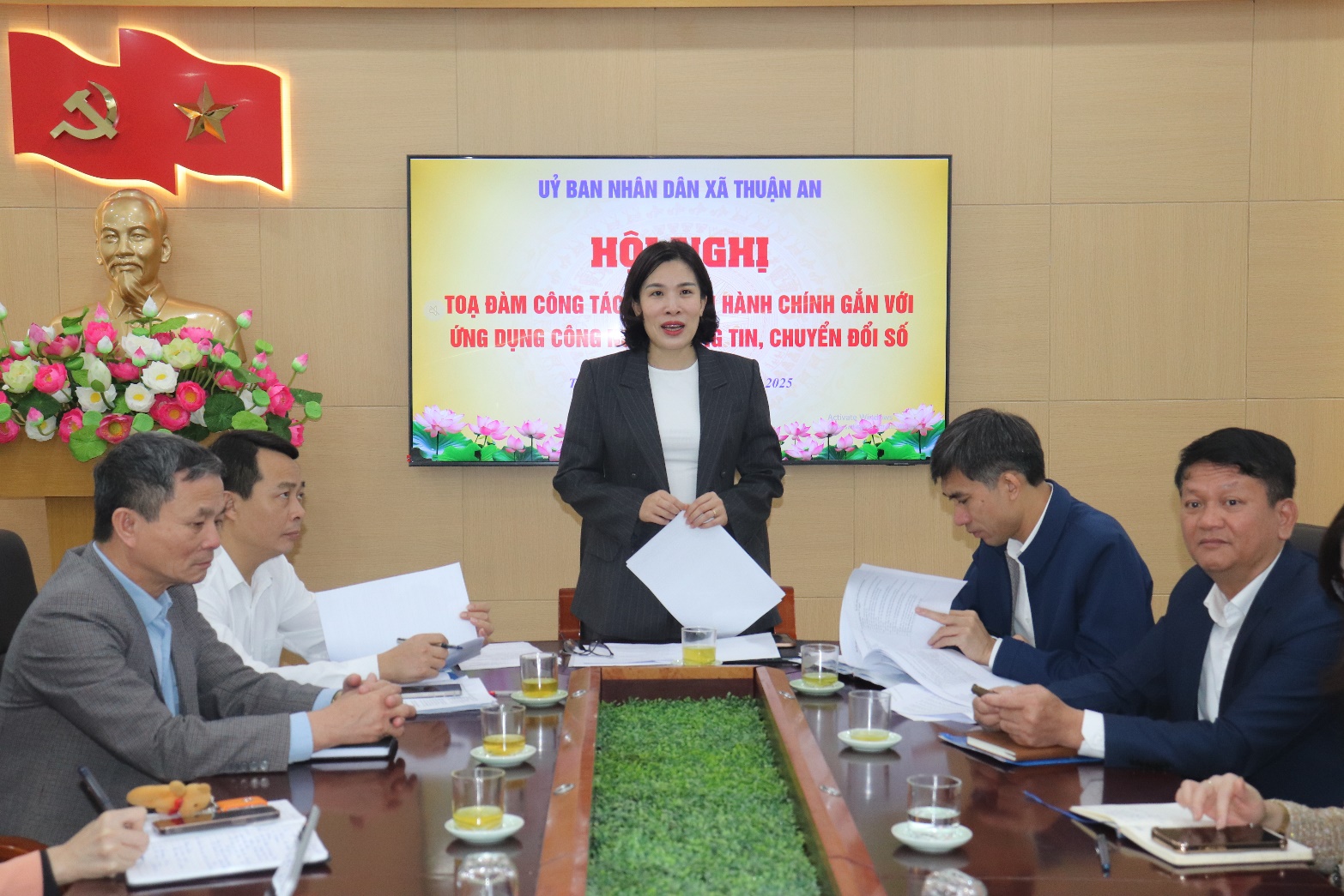 A person standing in front of a group of people sitting around a table  AI-generated content may be incorrect.