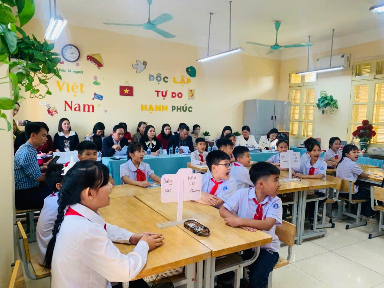 A group of students sitting at tables in a classroom  Description automatically generated