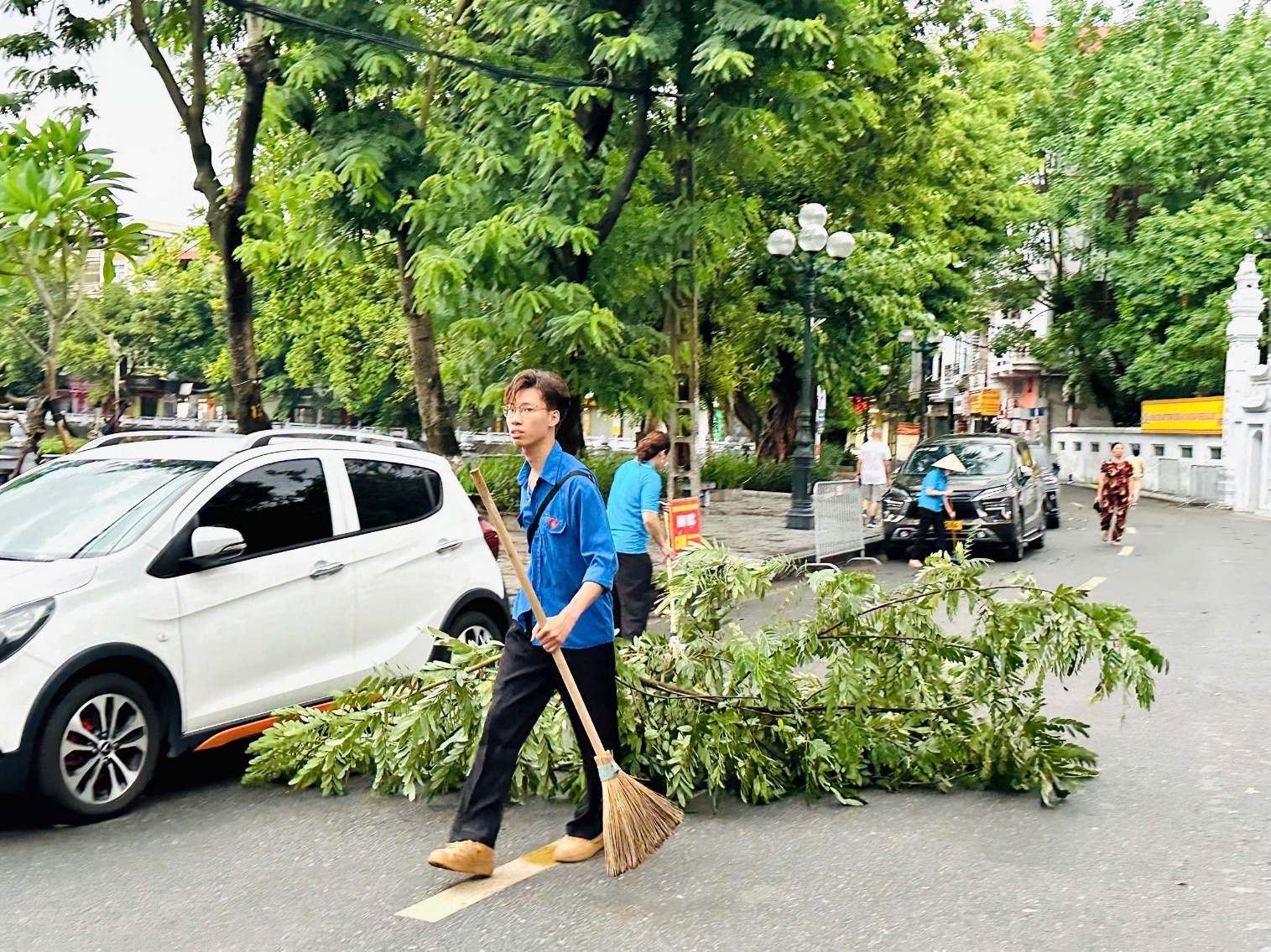 A person holding a broom next to a fallen tree  AI-generated content may be incorrect.