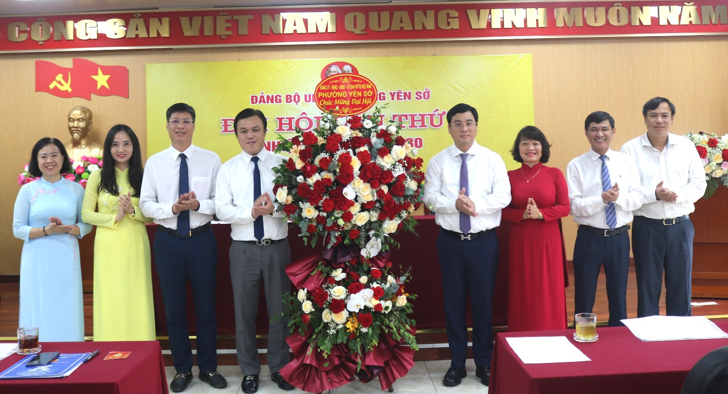 A group of people standing in front of a large flower arrangement  AI-generated content may be incorrect.