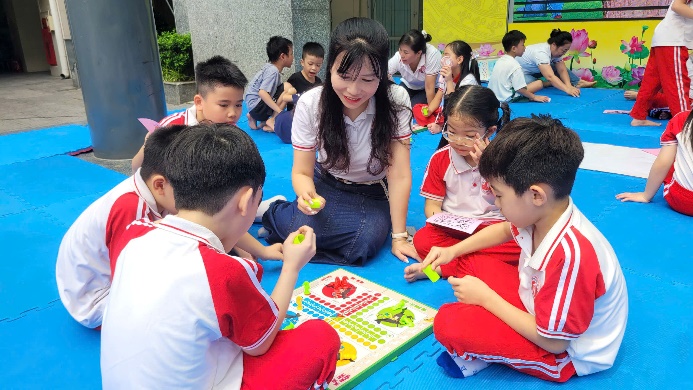 A group of children sitting on a blue mat  AI-generated content may be incorrect.