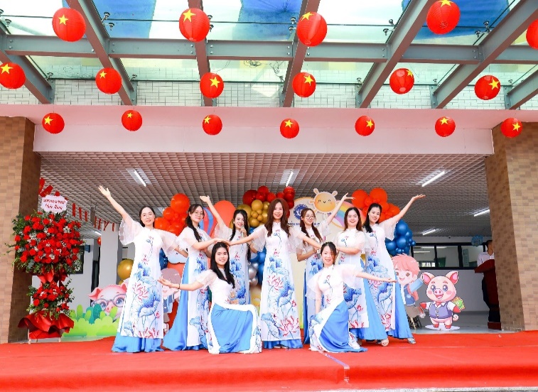 A group of women in dresses on a stage  Description automatically generated