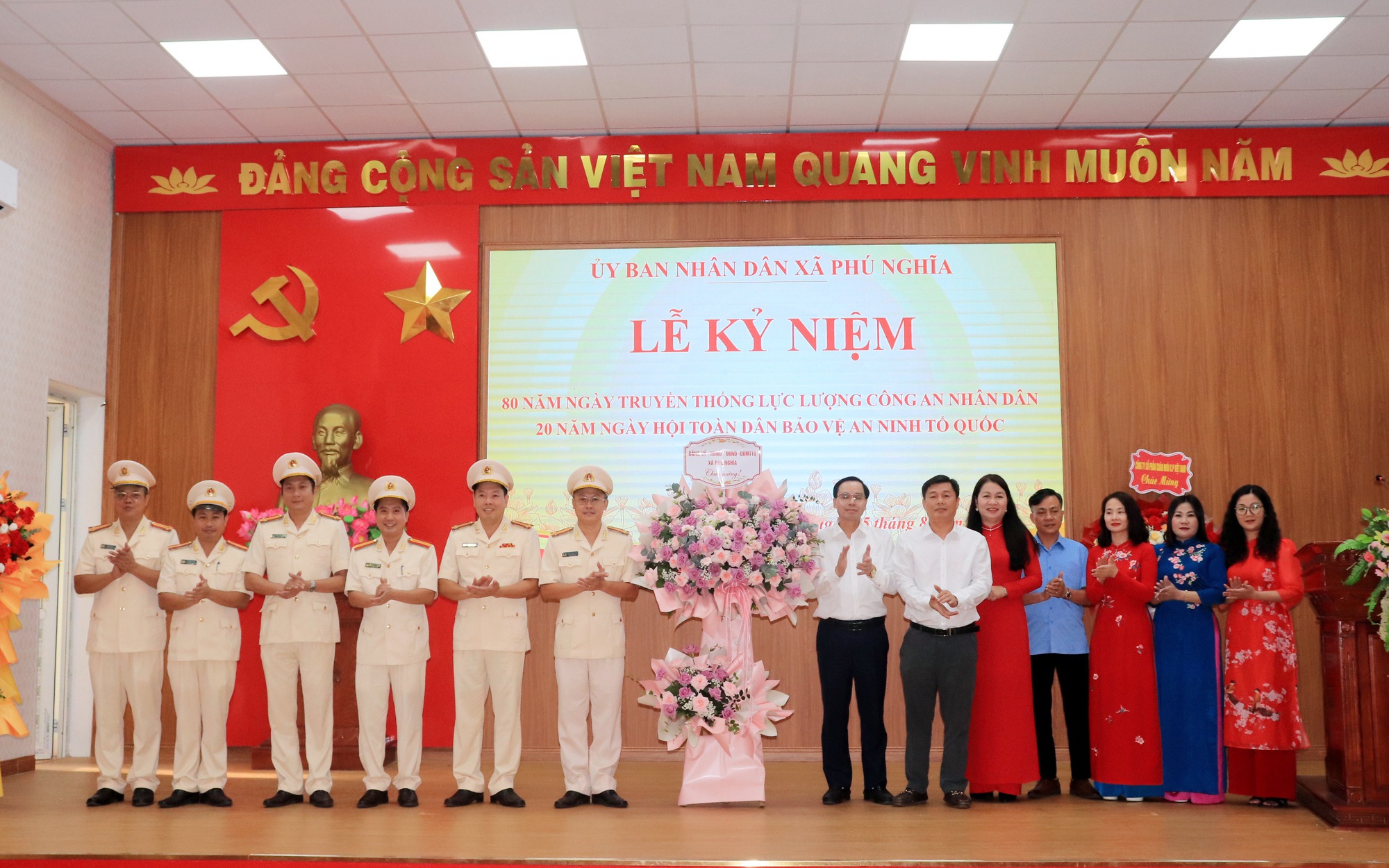 Các đồng chí trong Ban thường vụ Đảng ủy xã Phú Nghĩa tặng hoa chúc mừng Cán bộ, chiến sĩ Công an xã nhân dịp kỷ niệm 80 năm Ngày truyền thống Công an Nhân dân Việt Nam và 20 năm Ngày hội Toàn dân bảo vệ an ninh Tổ quốc.