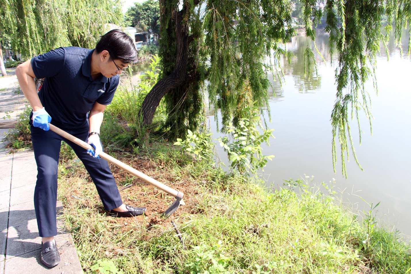 A person using a hoe to dig the ground  AI-generated content may be incorrect.