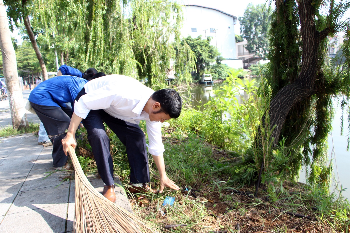 A person picking up a blue ball from a broom  AI-generated content may be incorrect.