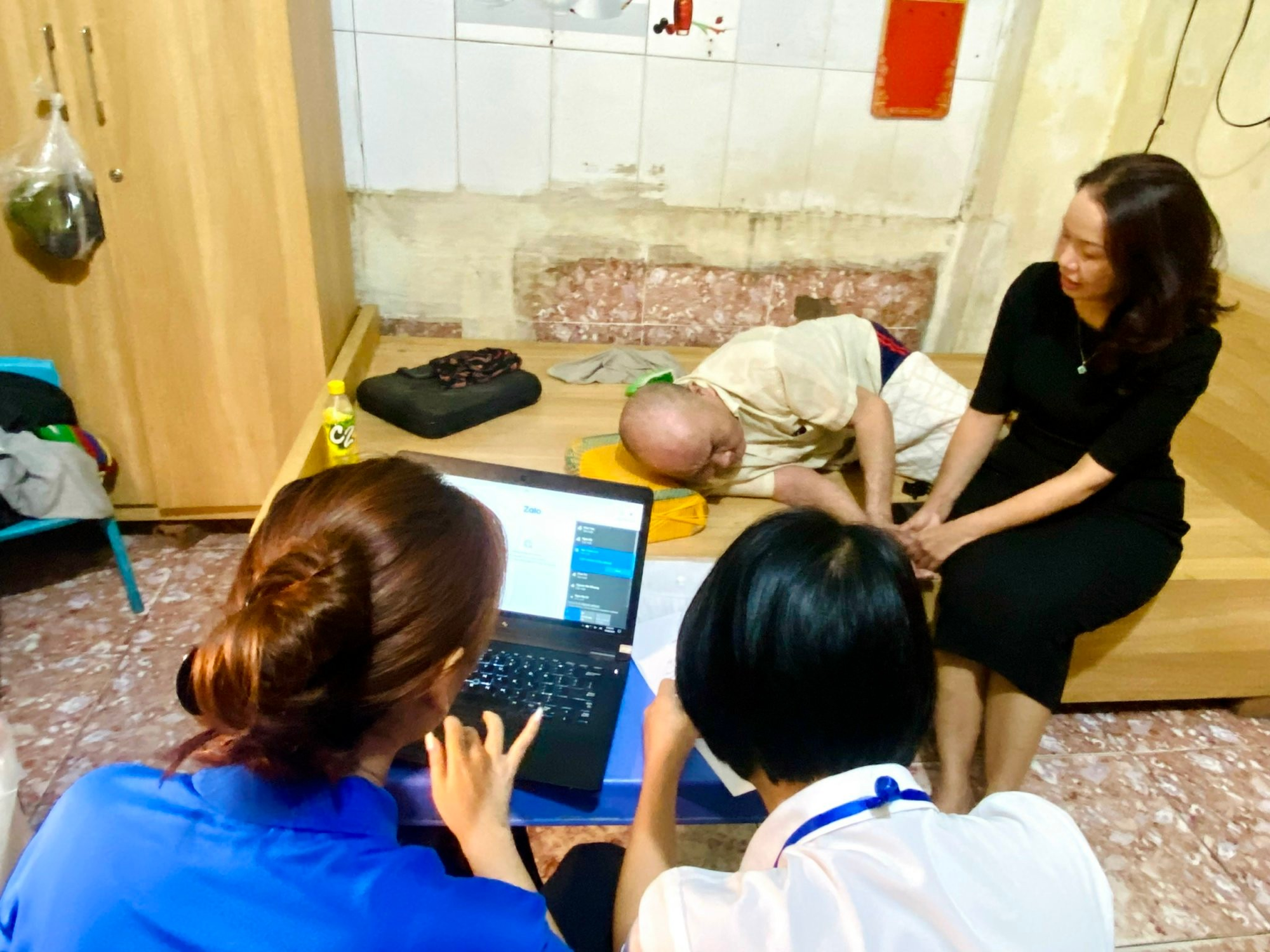 A group of people looking at a computer  Description automatically generated