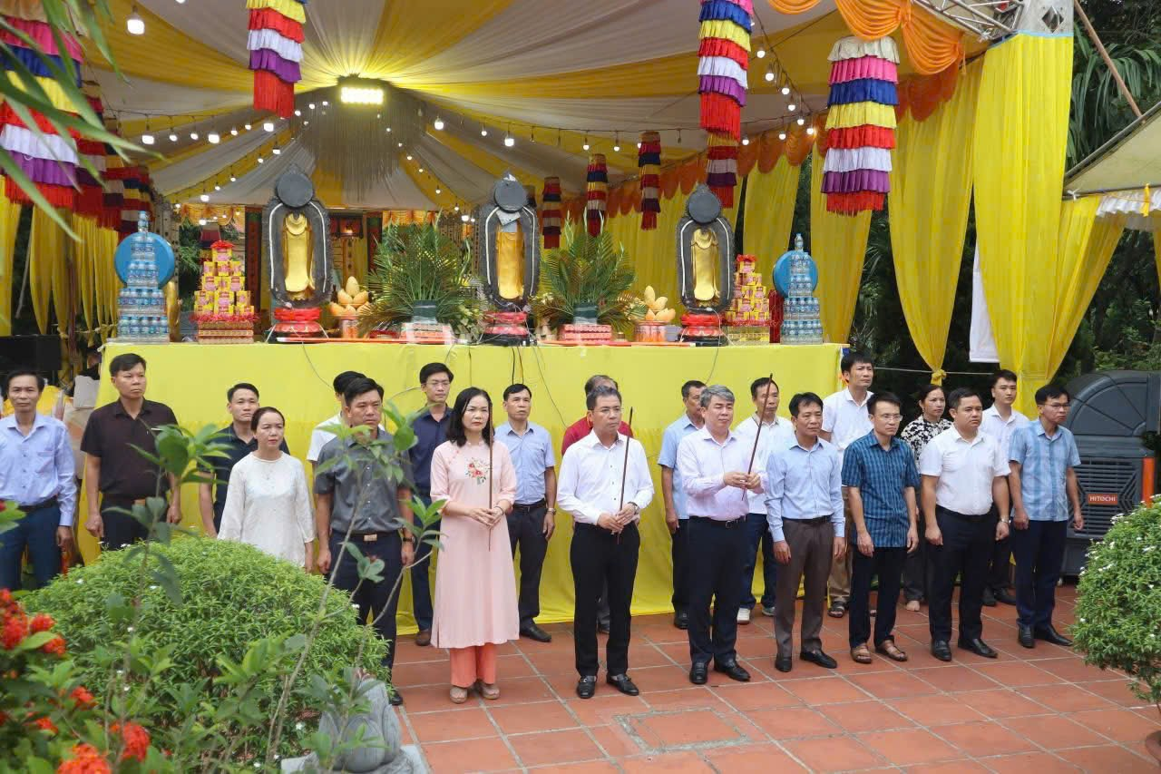 A group of people standing in front of a yellow and white tent  Description automatically generated