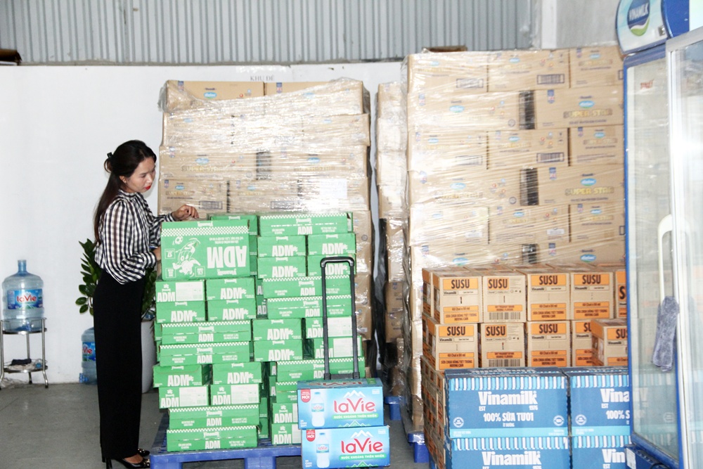 A person standing next to a stack of boxes  AI-generated content may be incorrect.