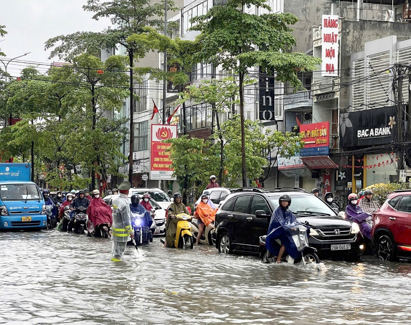 Công an xã Hoài Đức tăng cương đảm bảo an toàn giao thông, hỗ trợ người dân qua các điểm ngập úng- Ảnh 2.
