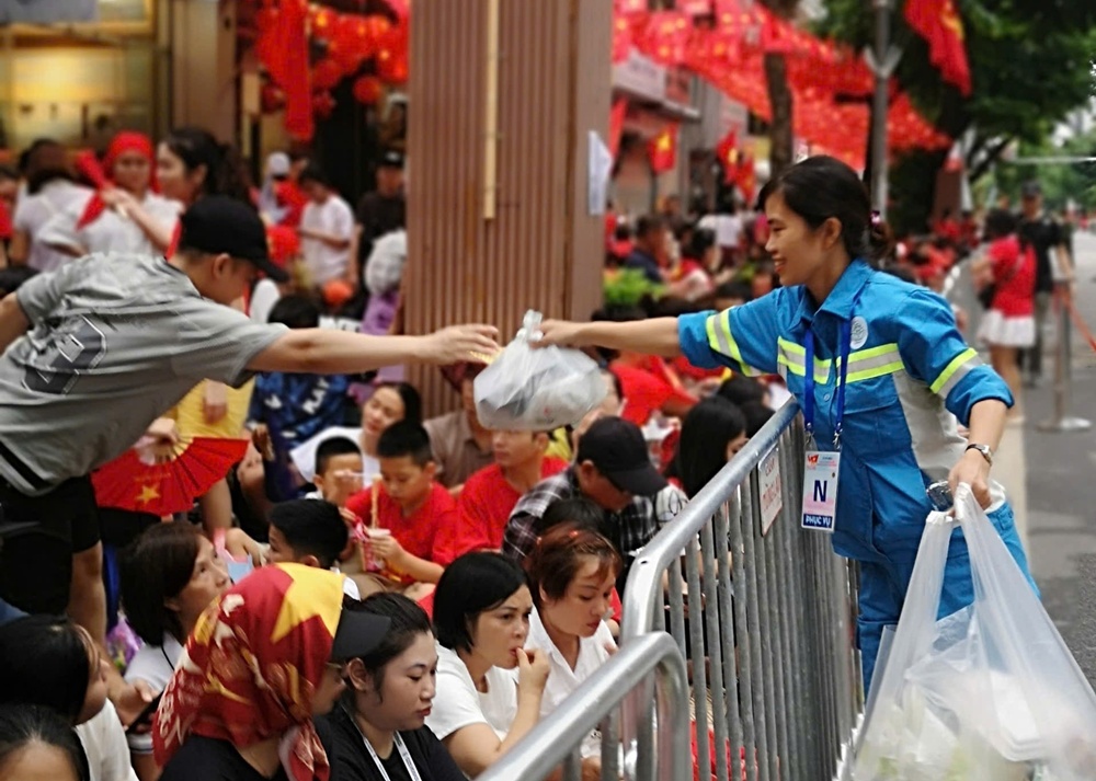 A person handing over plastic bags to a crowd of people  AI-generated content may be incorrect.