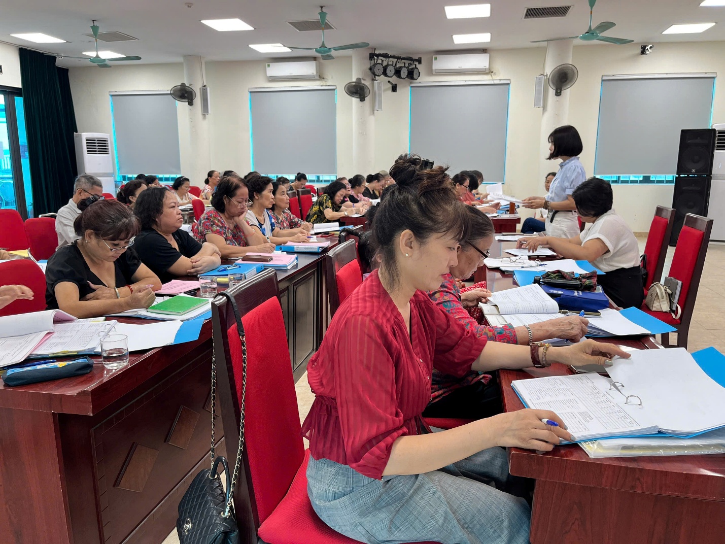 A group of people sitting at tables in a room  Description automatically generated