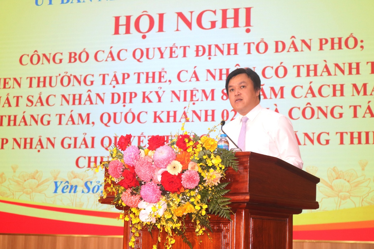 A person standing at a podium with flowers  AI-generated content may be incorrect.