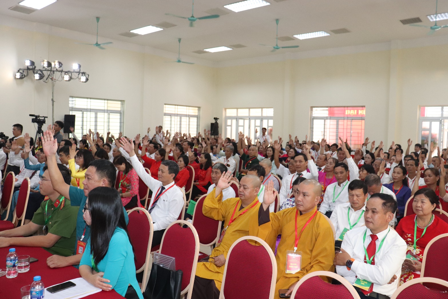 A group of people in a room raising their hands  AI-generated content may be incorrect.