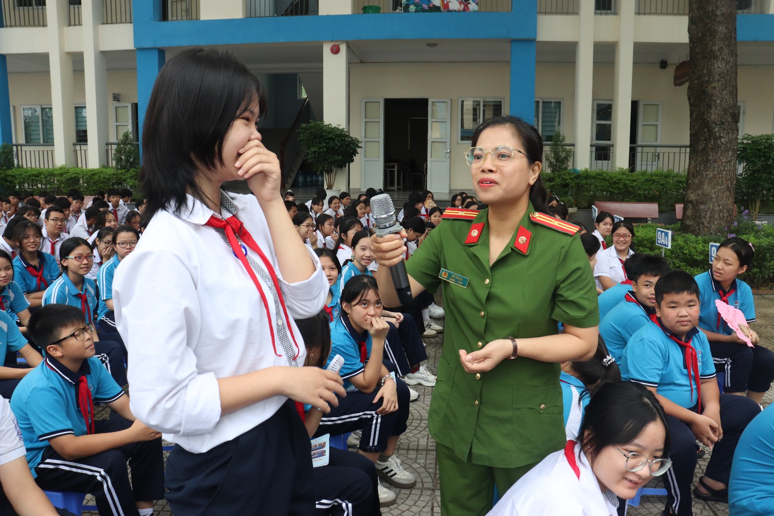 A person in uniform speaking to a person in front of a crowd  AI-generated content may be incorrect.