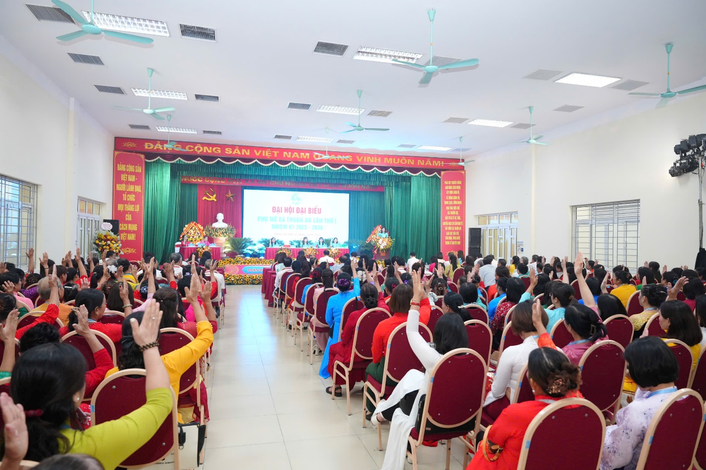 A group of people in a room raising their hands  AI-generated content may be incorrect.
