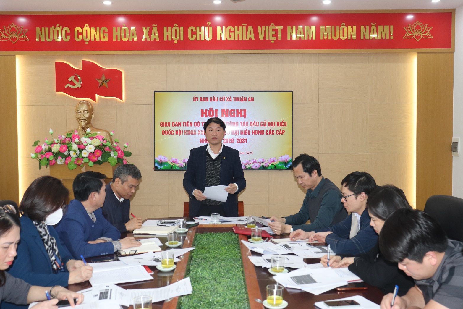 A person standing in front of a group of people sitting around a table  AI-generated content may be incorrect.