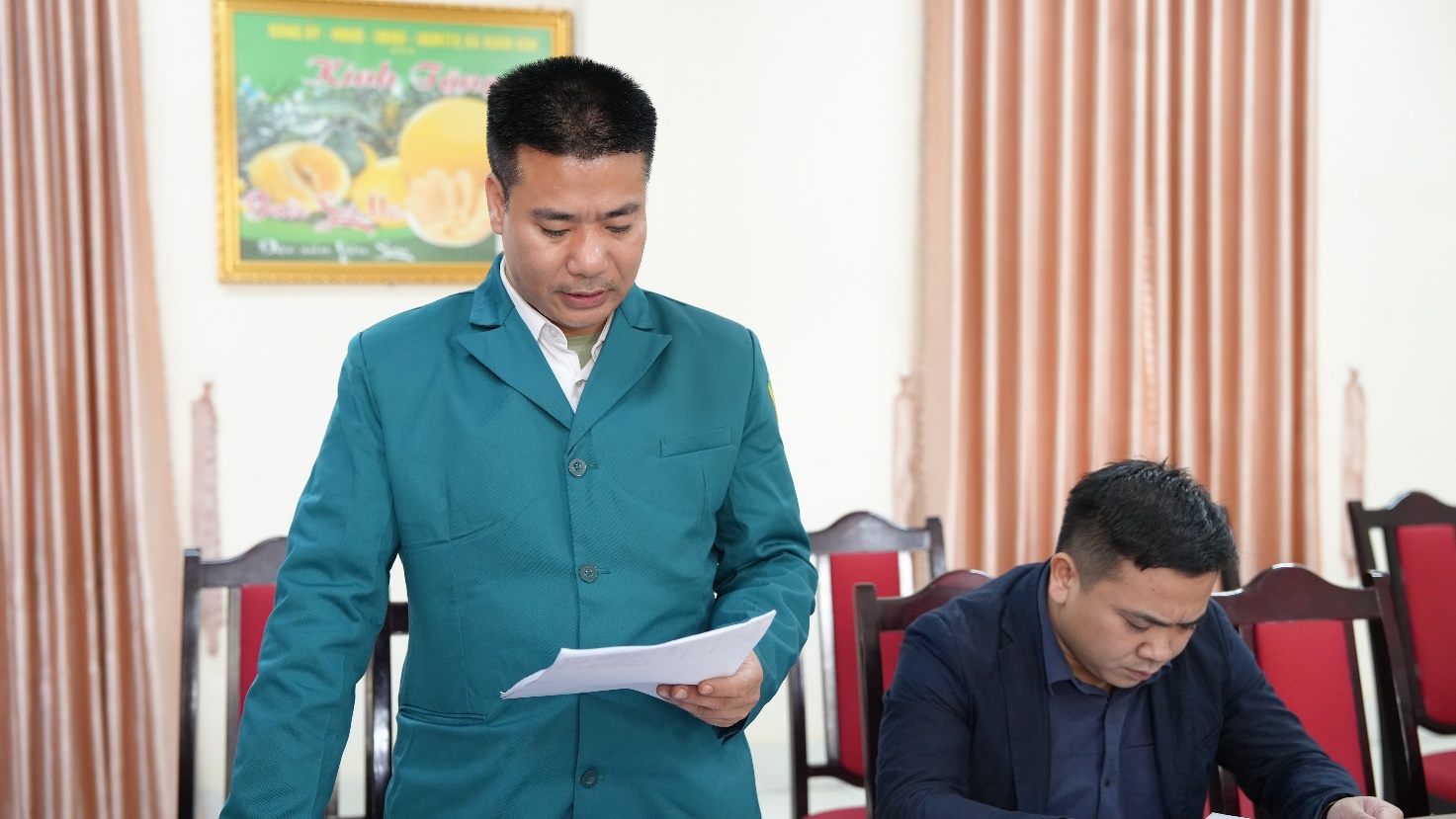 A person in a blue suit holding a piece of paper  AI-generated content may be incorrect.