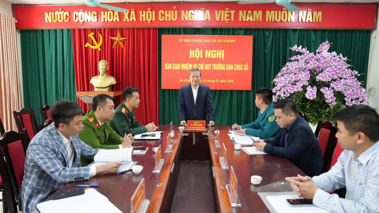 A person standing in front of a group of people sitting at a table  AI-generated content may be incorrect.