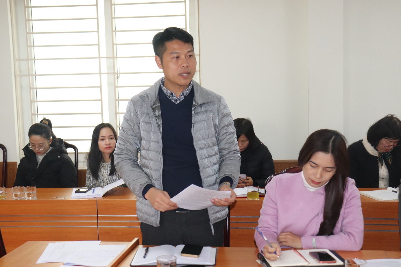 A person standing in front of a group of people  AI-generated content may be incorrect.